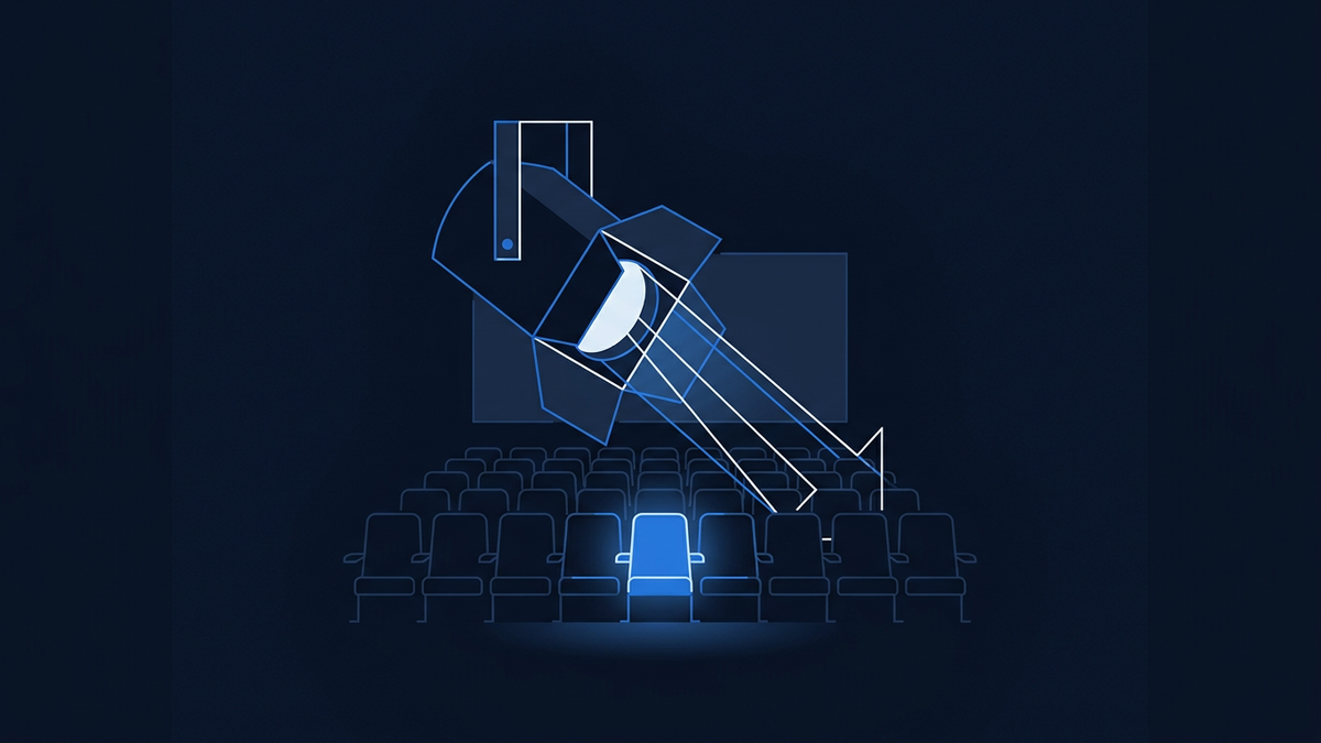 A single lit cinema seat facing an empty screen inside a darkened auditorium, with a wide vacant aisle sweeping toward the projection light