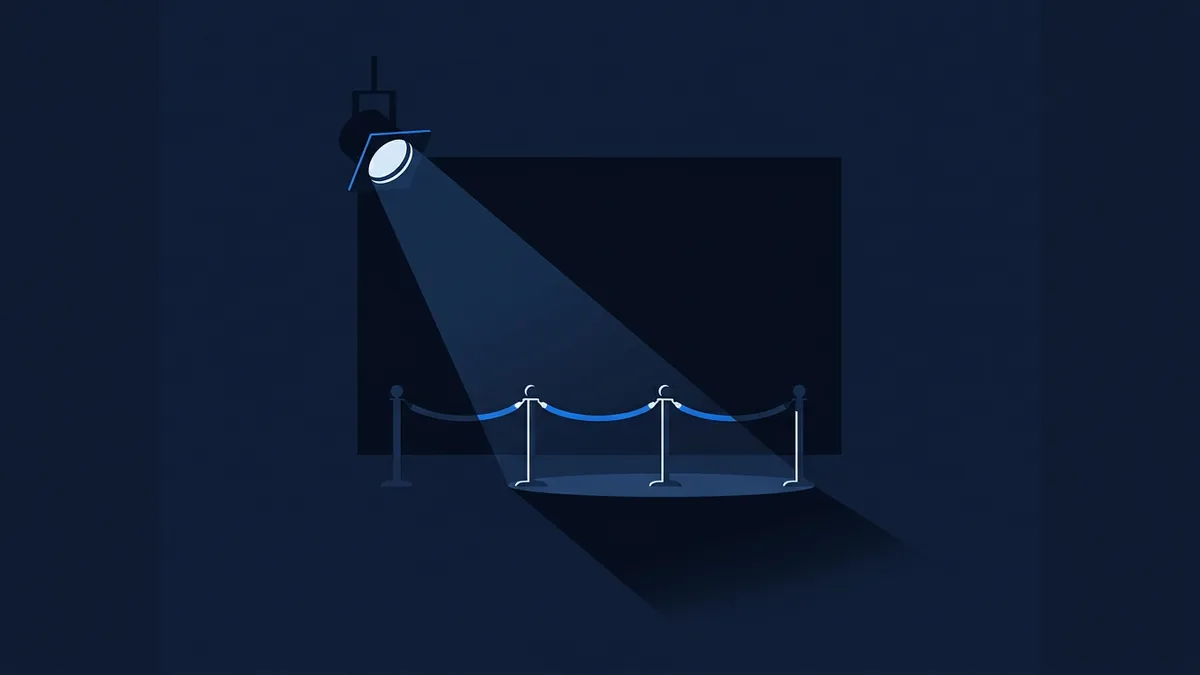 A solitary spotlight beam falling on an empty red-carpet stanchion line in a cavernous festival theatre, the stage beyond in shadow